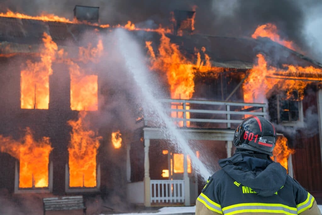 firefighter putting out house fire